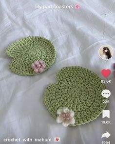 two crocheted placemats with flowers on them sitting on a white sheet