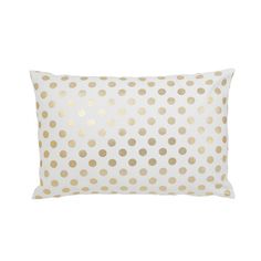 a white and gold polka dot pillow