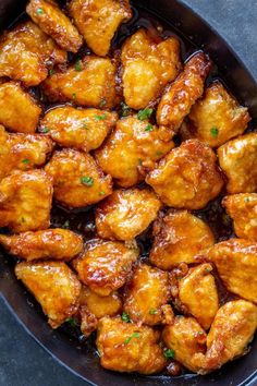 chicken wings in a skillet with sauce and parsley on the side, ready to be eaten