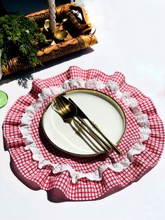 an empty plate on a red and white checkered table cloth with goldware in the background