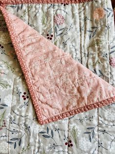 two pink and white quilts laying on top of each other