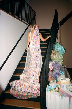 a woman in a wedding dress is standing on the stairs next to a table with confetti