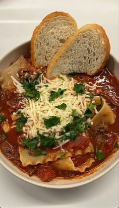 a bowl filled with pasta and bread on top of a table