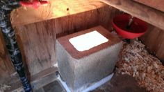 a red bucket sitting on top of a wooden box