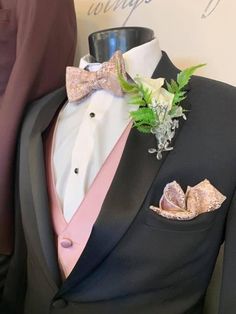 a man in a tuxedo with a pink bow tie and boutonniere