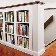 the bookshelf is built into the wall by the stairs