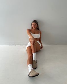 a woman sitting on the floor with her legs crossed