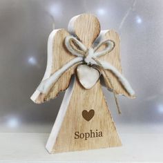 a wooden memorial angel with a heart on it's back and the words loving memory written in white