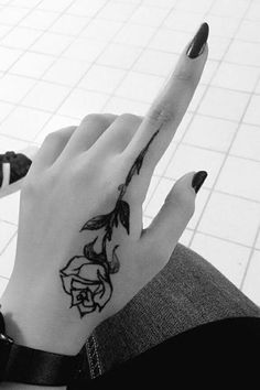 a woman's hand with a rose tattoo on it