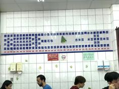 several people sitting at a table in front of a sign