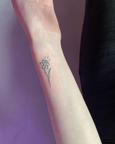 a woman's arm with a small flower tattoo on the left side of her wrist