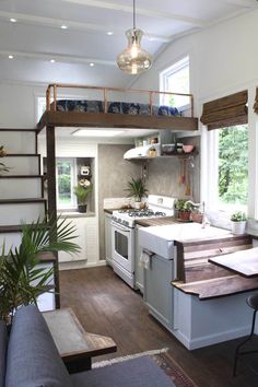 a kitchen with an island and stairs leading to the upper floor, next to a living room