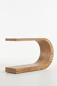 a wooden shelf with a curved design on the top and bottom, against a white background