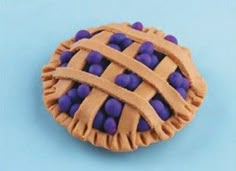 a chocolate pie with purple candies in it on a blue tableclothed surface