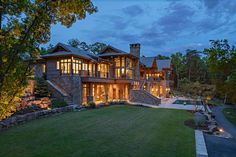 a large house with lots of windows and lights on it's front lawn area