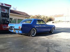 a blue car parked in front of a gas station