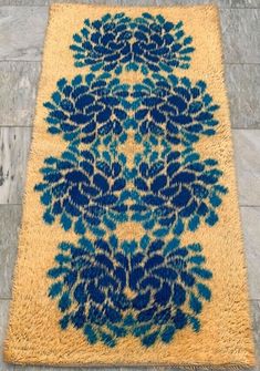 a blue and yellow rug on the ground