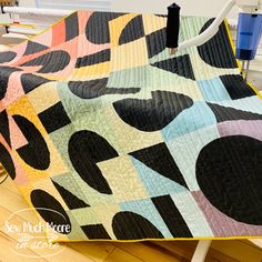 a colorful quilt on a chair in a room