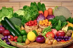 a basket filled with lots of different types of fruits and vegetables next to each other