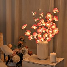 a vase filled with flowers sitting on top of a table next to a white candle