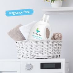 a white basket with towels and soap in it on top of a dryer next to a microwave