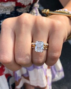 a close up of a person's hand with a ring on their finger and an engagement band