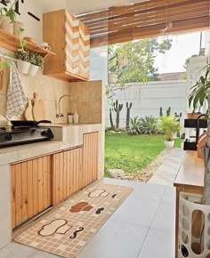 a kitchen area with an oven, sink and potted plant