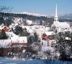 the town is covered in snow and surrounded by mountains