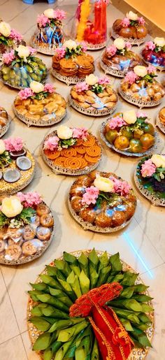 a table topped with lots of plates covered in food next to a vase filled with flowers