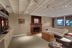 a living room filled with furniture and a flat screen tv mounted on a wall next to a fire place