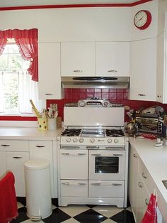 a white stove top oven sitting inside of a kitchen next to a sink and window