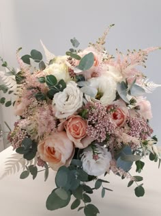 a bouquet of flowers and greenery on a table