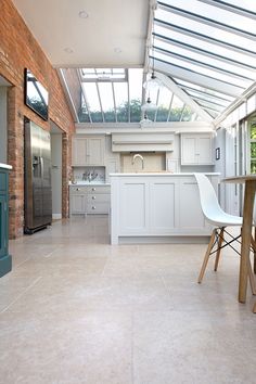 a kitchen with white cabinets and an open skylight above the counter top, along with a bar stool