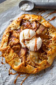 an apple pie topped with ice cream and caramel drizzled on top