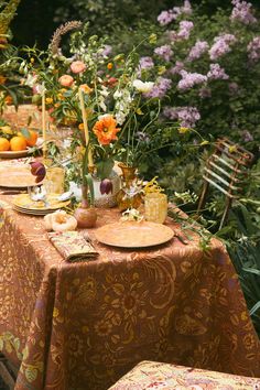 the table is set with oranges and flowers