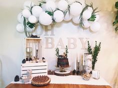 a baby shower with balloons and decorations on the wall, including cake, pineconi garlands and other items