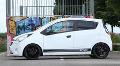 a small white car parked in a parking lot