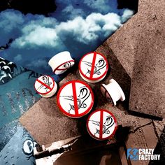 four red and white signs sitting on top of a cement slab next to water with clouds in the background