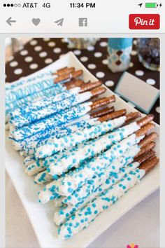 there is a white plate with blue sprinkles and pretzels on it