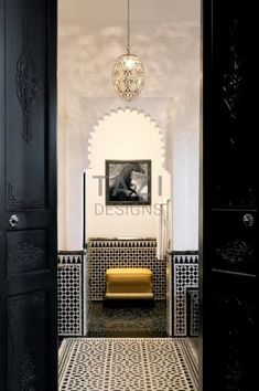 an open door leading into a room with black and white tiles on the floor, walls and ceiling