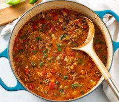 a blue pot filled with soup and a wooden spoon