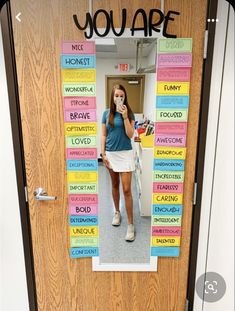 a woman standing in front of a door with words written on it and the word you are