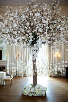 a wedding tree with white flowers and ribbons