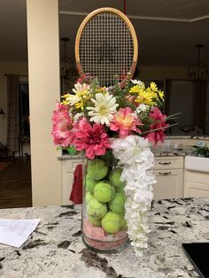 a vase filled with tennis balls and flowers