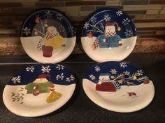 four plates with designs on them sitting on a counter