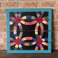 a painting on wooden planks that has been painted with different colors and shapes in the shape of circles