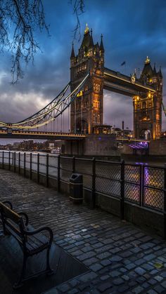 the tower bridge is lit up at night