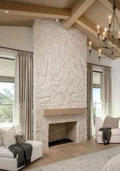 a living room filled with furniture and a fire place under a chandelier over a fireplace