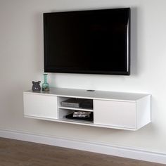 a flat screen tv mounted to the side of a white entertainment center in a living room