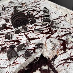 an oreo cookie cake with white frosting and chocolate drizzle on top